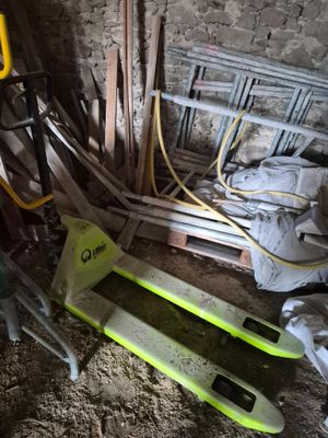 un tas d'outils posé par terre à côté d'un tas de bois