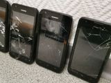 four cell phones are sitting next to each other on the floor