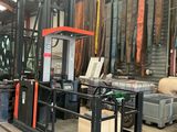 a fork lift truck in a warehouse with lots of items