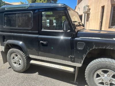 une Land Rover noire garée sur le bord de la route