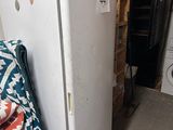 a white refrigerator in the corner of a room next to a washer and dryer
