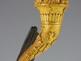 an image of a gold and black vase with flowers on it