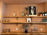 a shelf with bottles and glasses on it in a room