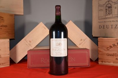 a bottle of wine sitting on a table next to a stack of wooden boxes