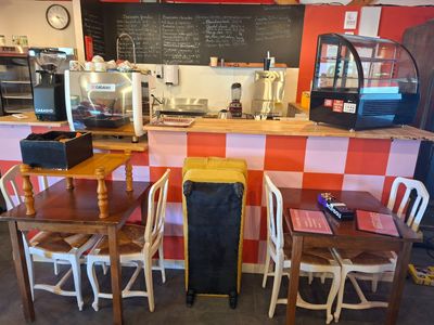 des tables et des chaises dans un restaurant avec un tableau noir accroché au mur