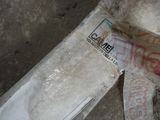 a bag of rice sitting on the ground next to a knife