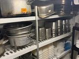 many pots and pans on the shelves in the kitchen