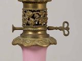 a white and pink vase with a gold base
