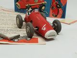 a red toy car sitting on top of an open book