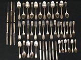 many forks and spoons laid out on a black surface