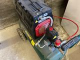 a small air compressor sitting on the floor next to a wall