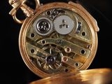 a close up of a gold pocket watch on a black background