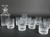 six verres et une carafe posés sur une table