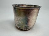 a silver cup that is sitting on a table