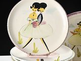 a stack of plates with a picture of a woman and a cat on them