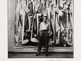 black and white photograph of a man standing in front of a painting