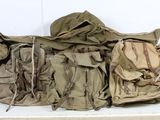 une pile de sacs à dos militaires posée sur une étagère