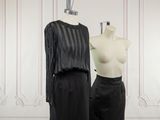 two mannequins in front of a white wall and a black dress on a mannequin stand