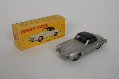 un gros plan d'une petite voiture à côté d'une boîte de « Dinky Toys »