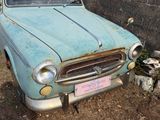 an old car that is sitting in the dirt