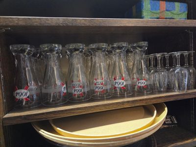 une étagère en bois sur laquelle se trouvent de nombreux verres et assiettes vides