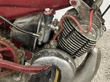 a close up of an old motorcycle with a red seat