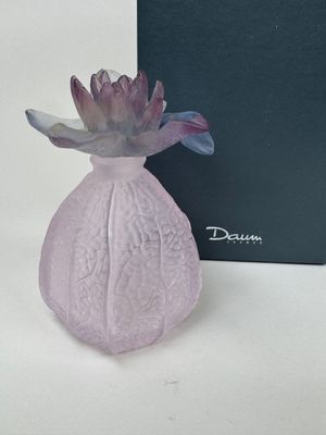 purple glass vase with a purple flower in front of a black box