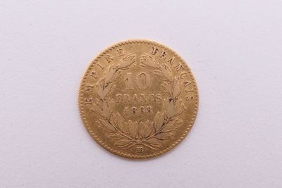 gros plan d'une pièce d'or sur une surface blanche