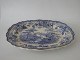 an old blue and white platter with a landscape scene on it