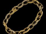 un bracelet à maillons en or avec un fermoir, sur fond noir