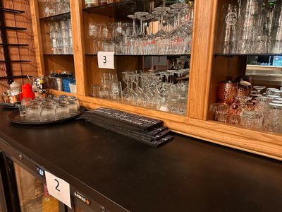 a black counter top with a bunch of glasses on it