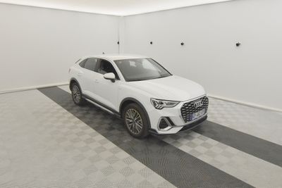 un SUV Audi blanc garé dans un garage au sol carrelé
