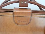 a close up of a brown leather bag on a table