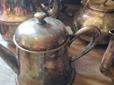 many silver teapots sitting on a table next to each other
