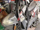 a scooter parked in a garage with tools on the wall