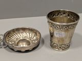 une tasse et une soucoupe plaquées argent posées sur une table blanche