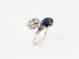 a close up of a diamond and sapphire ring on a white background