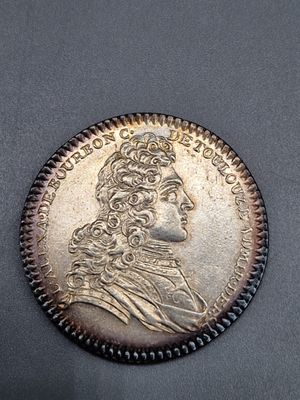 une pièce d'argent à l'effigie d'un homme coiffé d'une couronne