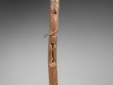 une image représentant une sculpture en bois d'une personne tenant une canne