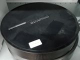 une casserole noire posée dans un micro-ondes, sur un plan de travail