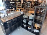 Des bouteilles de vin et des verres sont exposés dans un caviste.