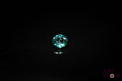 gros plan d'un diamant vert sur une surface noire