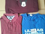 three t - shirts are sitting on a cardboard box on the floor