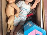 a doll and a doll in a box on the floor