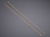a pair of gold chain bracelets on a grey background