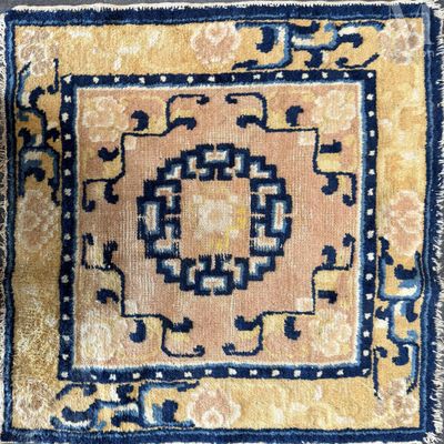 un gros plan sur un tapis jaune et bleu orné d'un motif en médaillon
