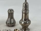 silver plated salt and pepper shakers and spoons on a table