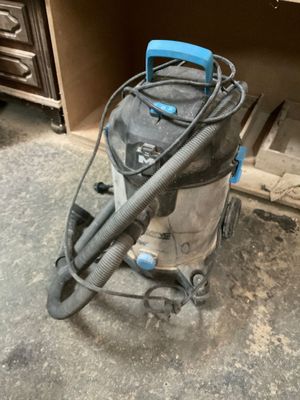 un aspirateur posé par terre devant une armoire