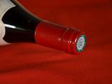 a bottle of wine that is on a red cloth