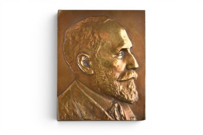 a bronze plaque of a man with a beard